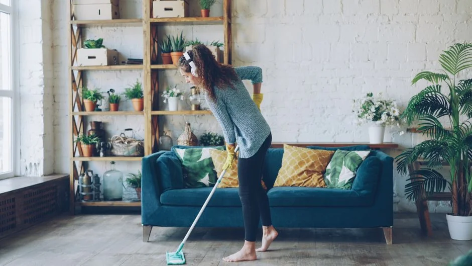 our-story A woman carefully wraps a sofa in protective material while packing boxes in a bright room.
